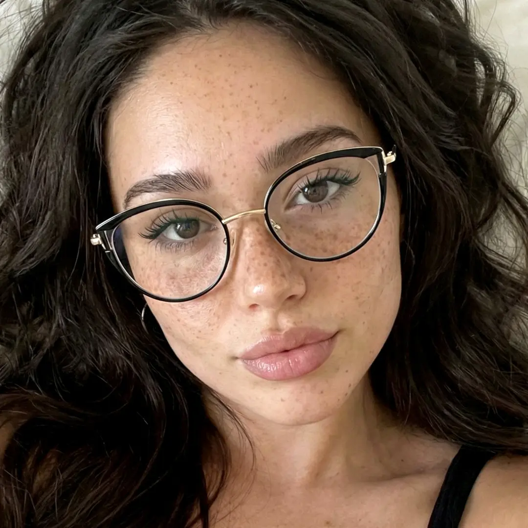 Front view of female wearing black cat eye eyeglasses, relaxed expression, CR0182411