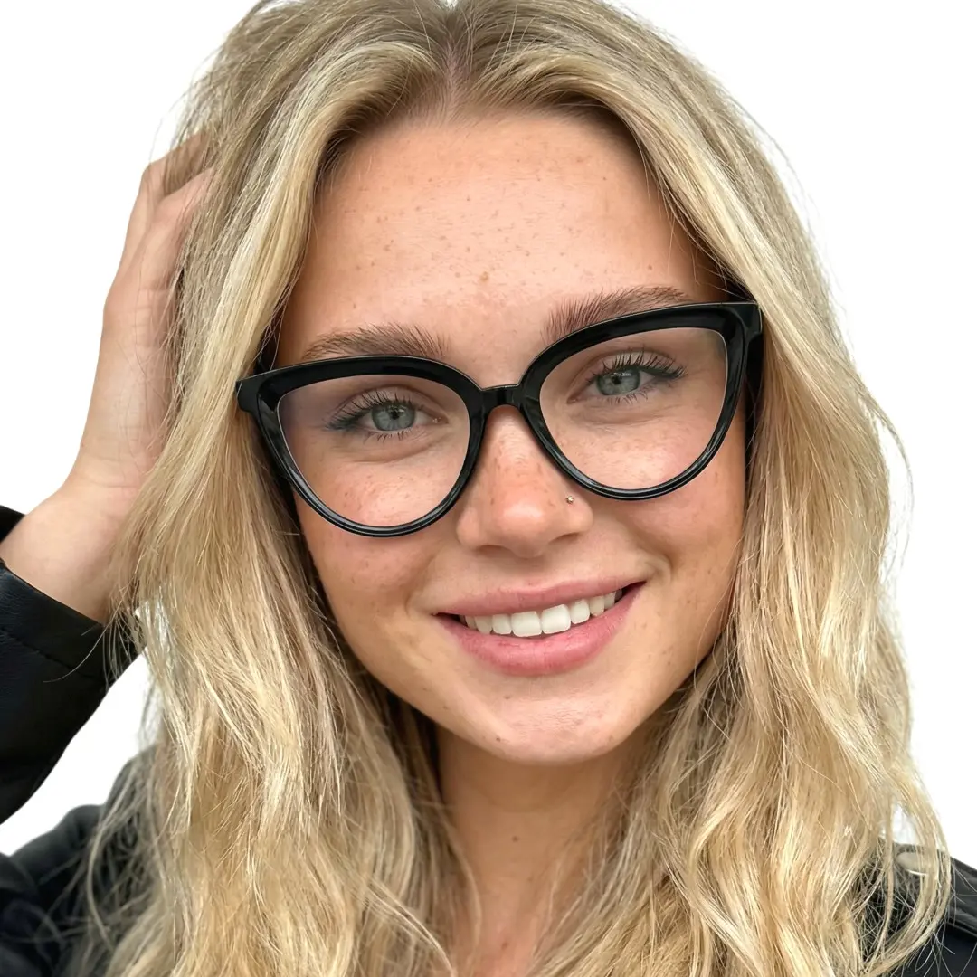 Front view of female wearing black cat eye eyeglasses, hand in hair, natural smile, CR0222411