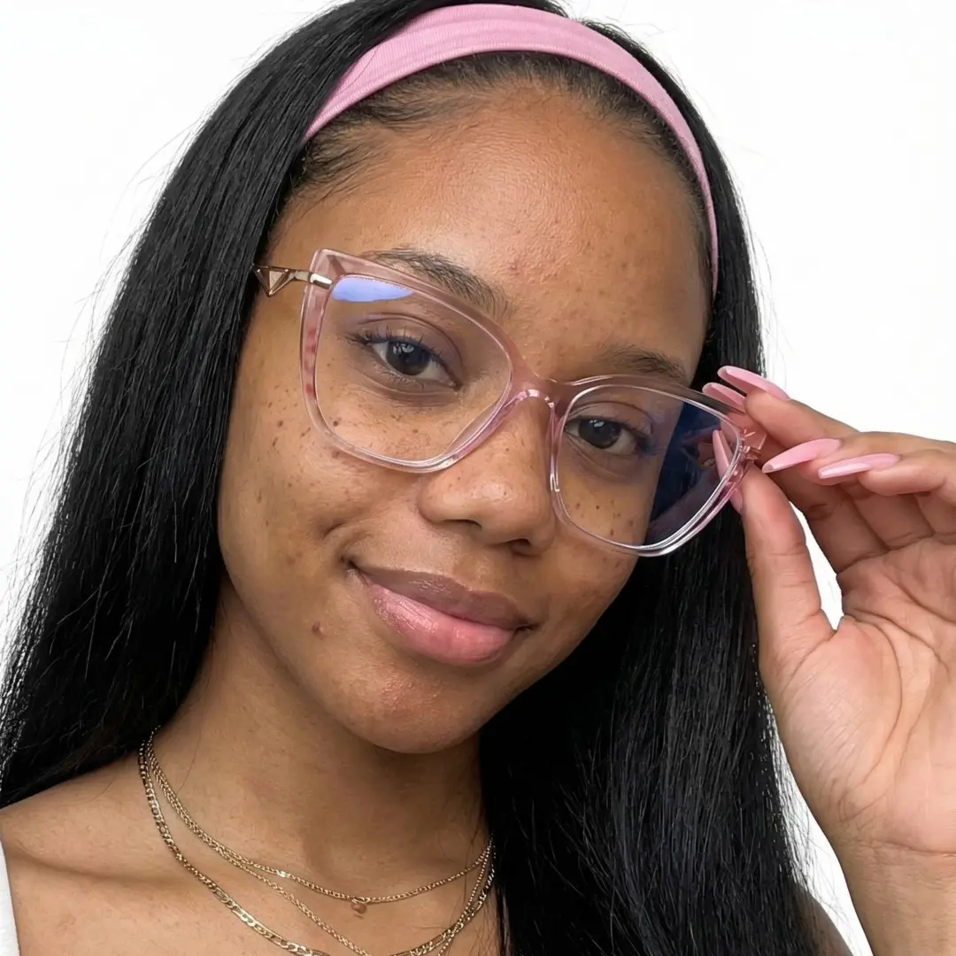 Tilted head view of female wearing pink cat eye eyeglasses, adjusting glasses, natural smile, CR0252408