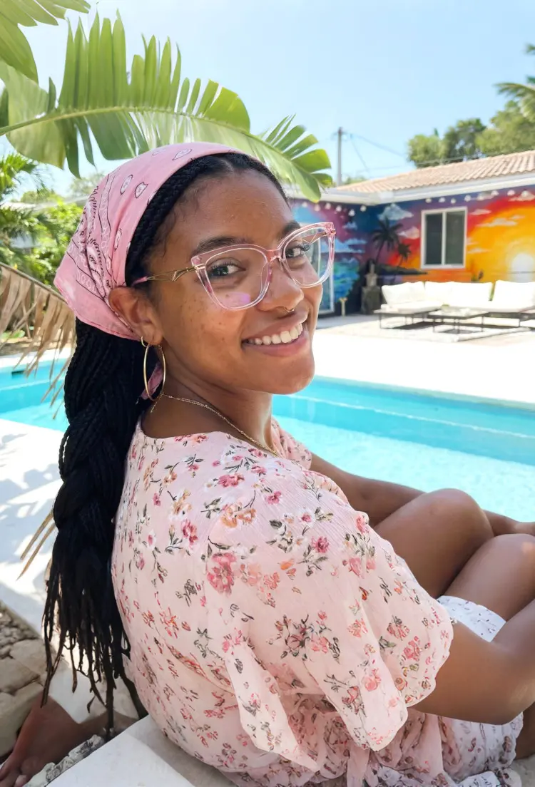 Female model wearing everyday glasses pink cat eye tr90 eyeglasses by a sunny poolside. SPU: CR0252408