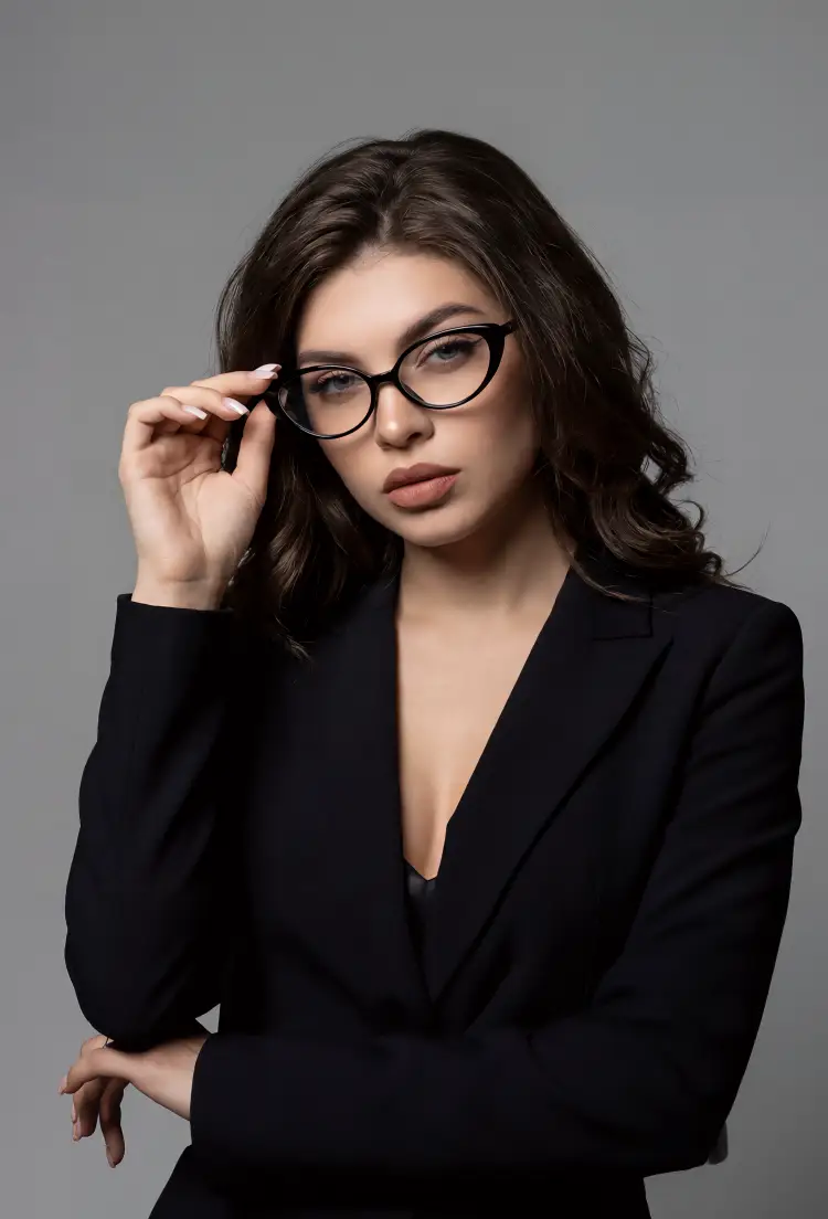 Female model wearing office siren black cat eye tr90 eyeglasses in a professional black blazer against a studio solid grey background. SPU: CR0382601