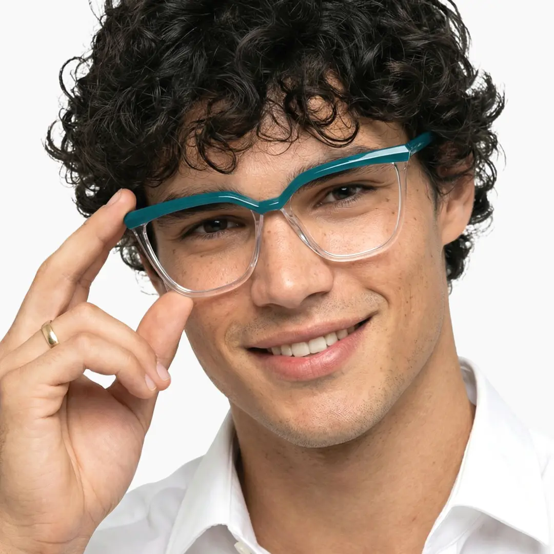 Front view of male wearing green cat eye eyeglasses, holding glasses, CR0442302