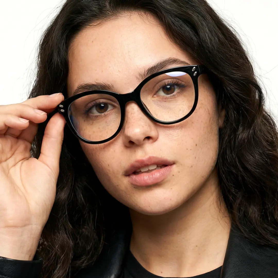 Close-up view of female wearing black cat eye eyeglasses, touching frame, natural expression, CR0472504