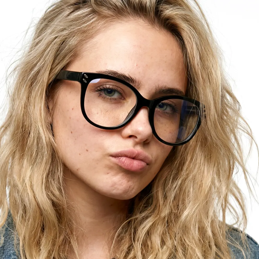 Three-quarter view of female wearing black cat eye eyeglasses, pouting, cute expression, CR0472504