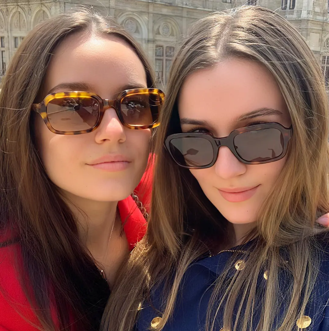 Slightly angled view of two people wearing vintage tortoise rectangle eyeglasses, natural expression, EA0022311