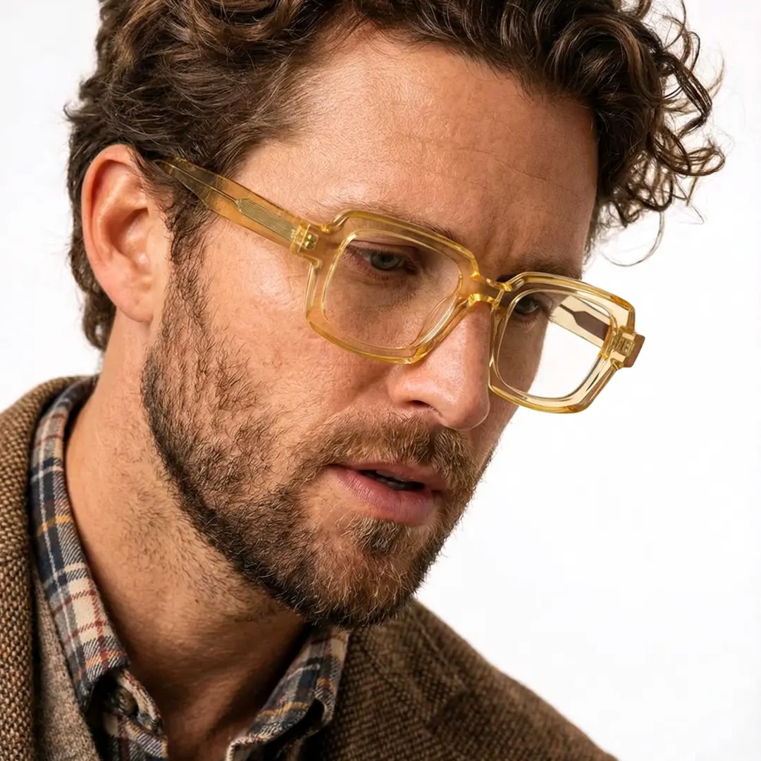 Looking away view of male wearing yellow rectangle eyeglasses, thoughtful expression, EA0072302