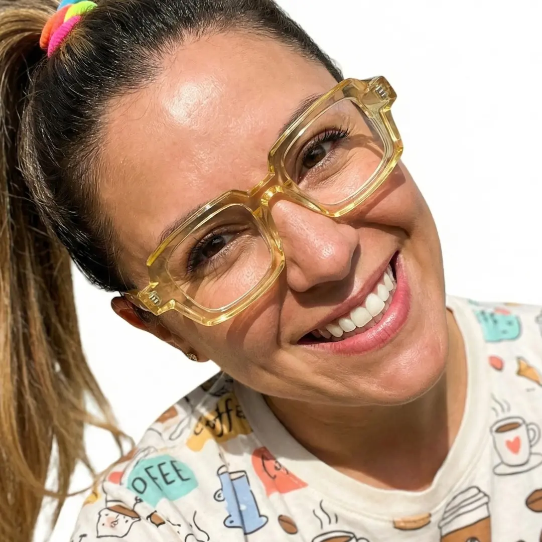 Face close-up view of female wearing yellow rectangle eyeglasses, tilting head, friendly smile, EA0072302