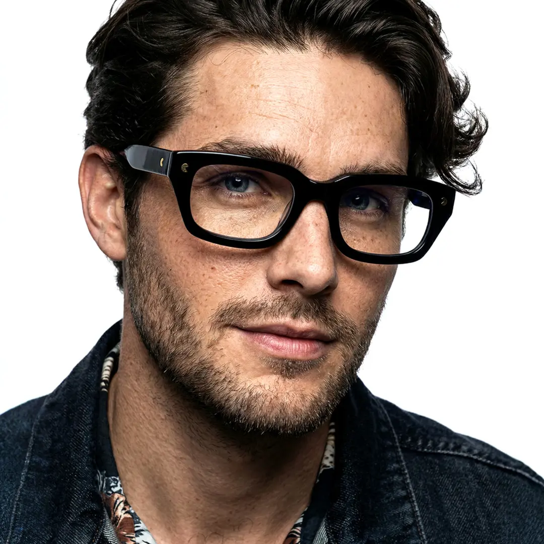 Three-quarter view of male wearing nerd black rectangle eyeglasses, natural smile, EA0072305