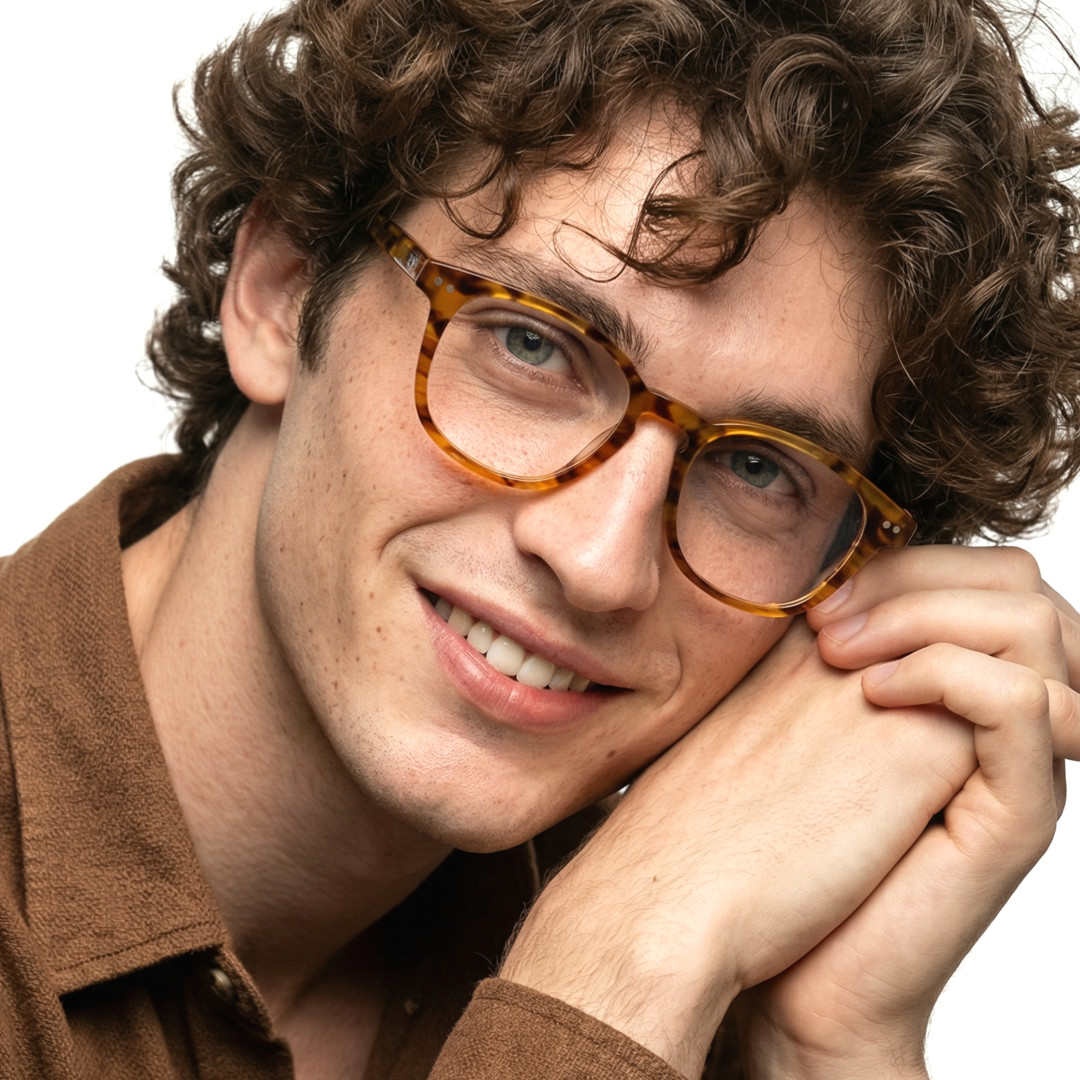 Front view of male wearing colorful tortoise rectangle eyeglasses, tilting head, smiling, EA0142209