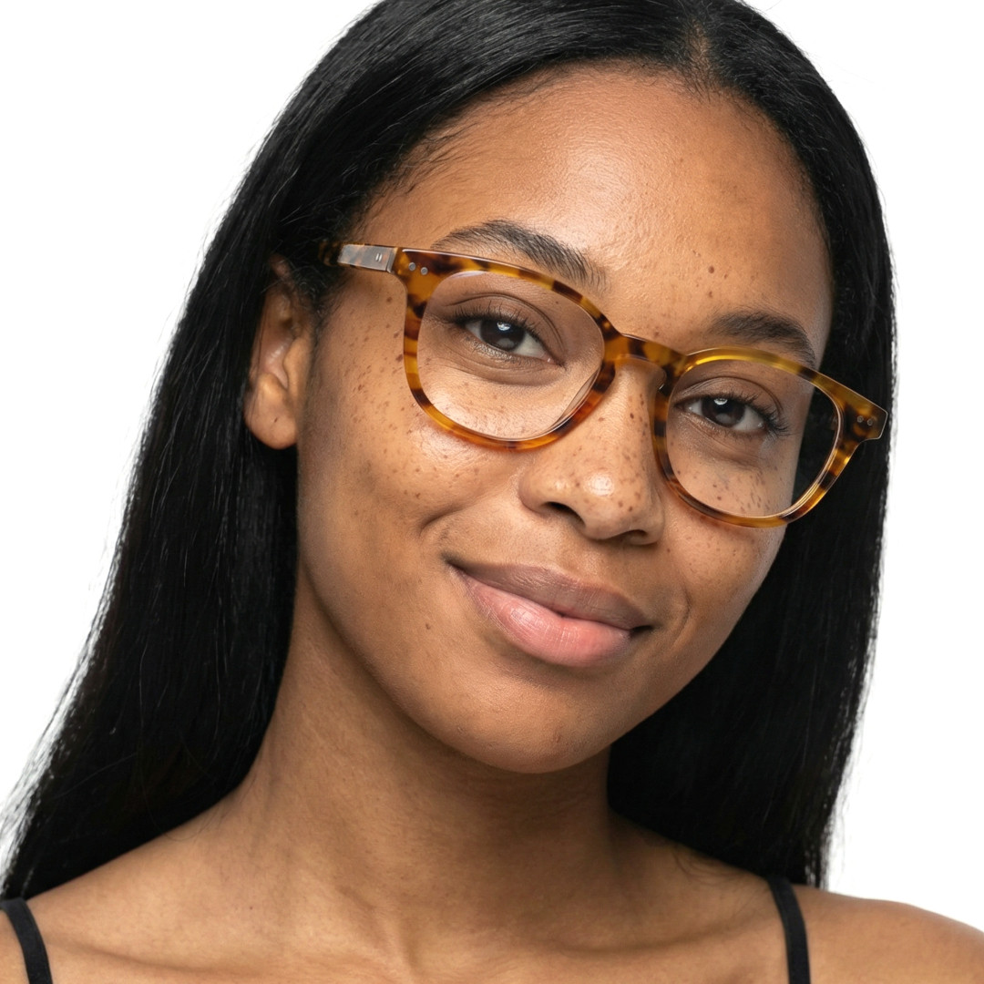 Front view of female wearing colorful tortoise rectangle eyeglasses, tilting head, natural smile, EA0142209