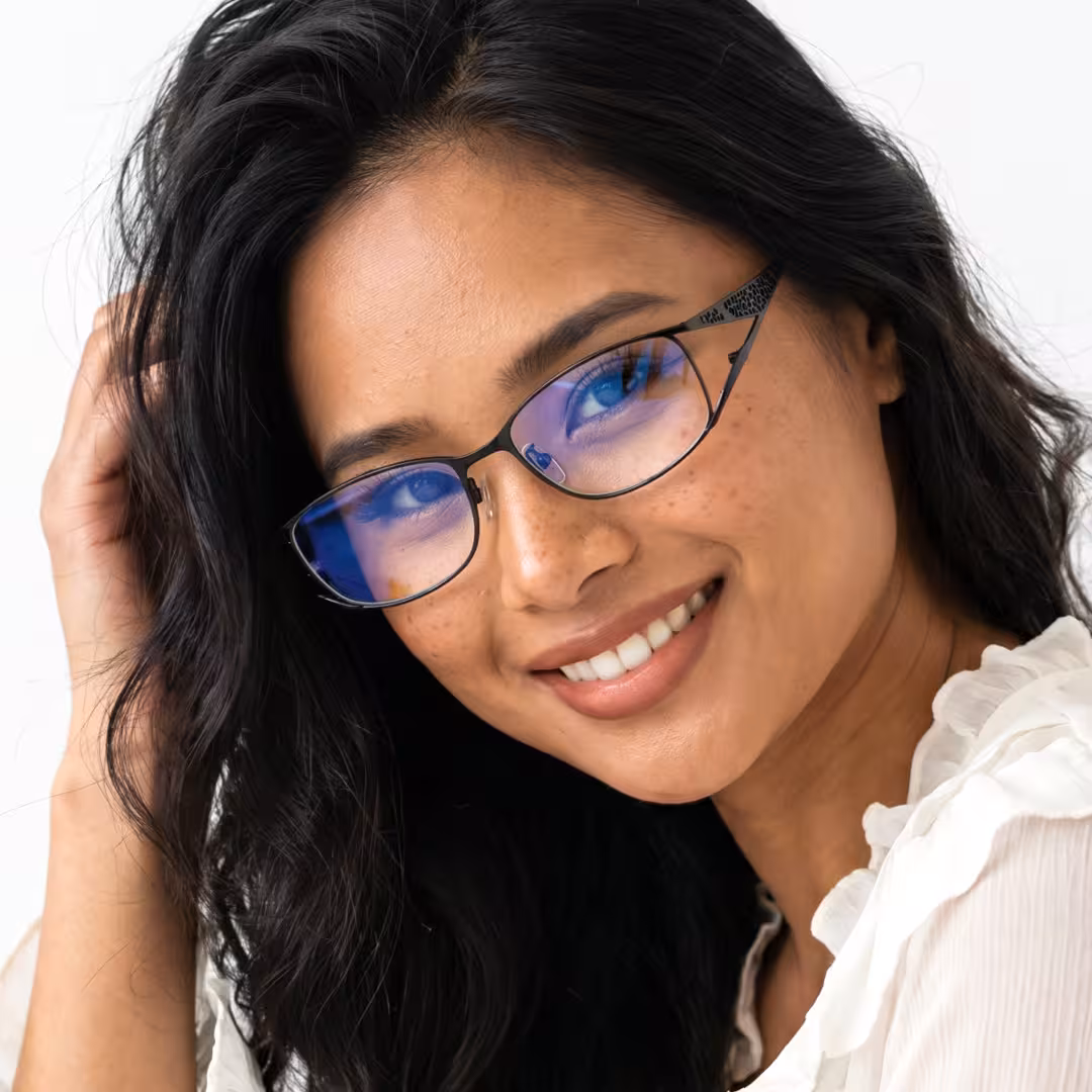 Front view of female wearing office siren black rectangle eyeglasses, hand in hair, smiling, EM0252605