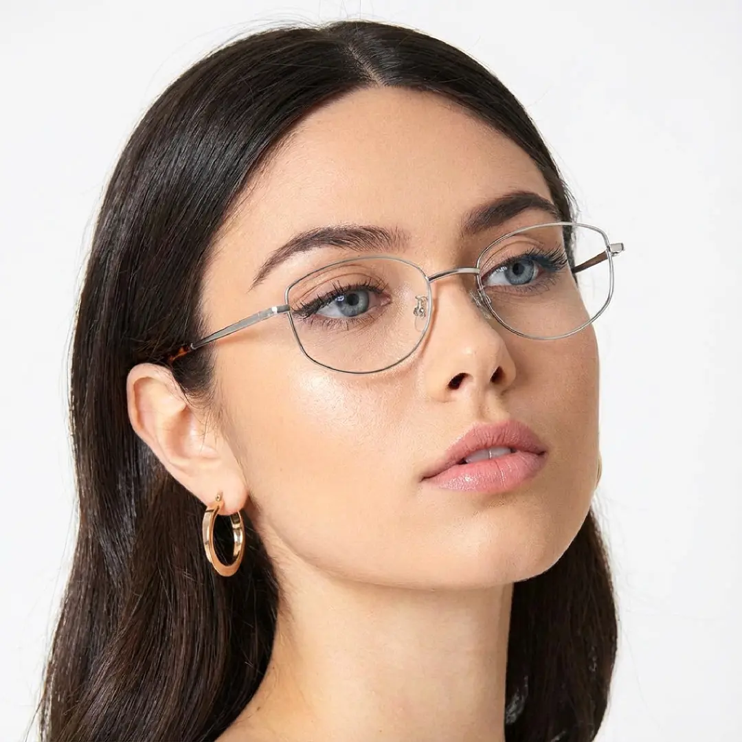 Tilted head view of female wearing silver rectangle eyeglasses, neutral expression, EM0422509