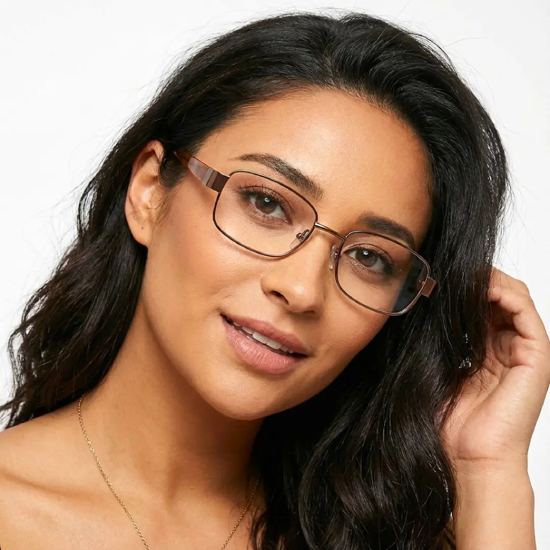 Tilted head view of female wearing office siren brown rectangle eyeglasses, hand in hair, smiling, EM0532509
