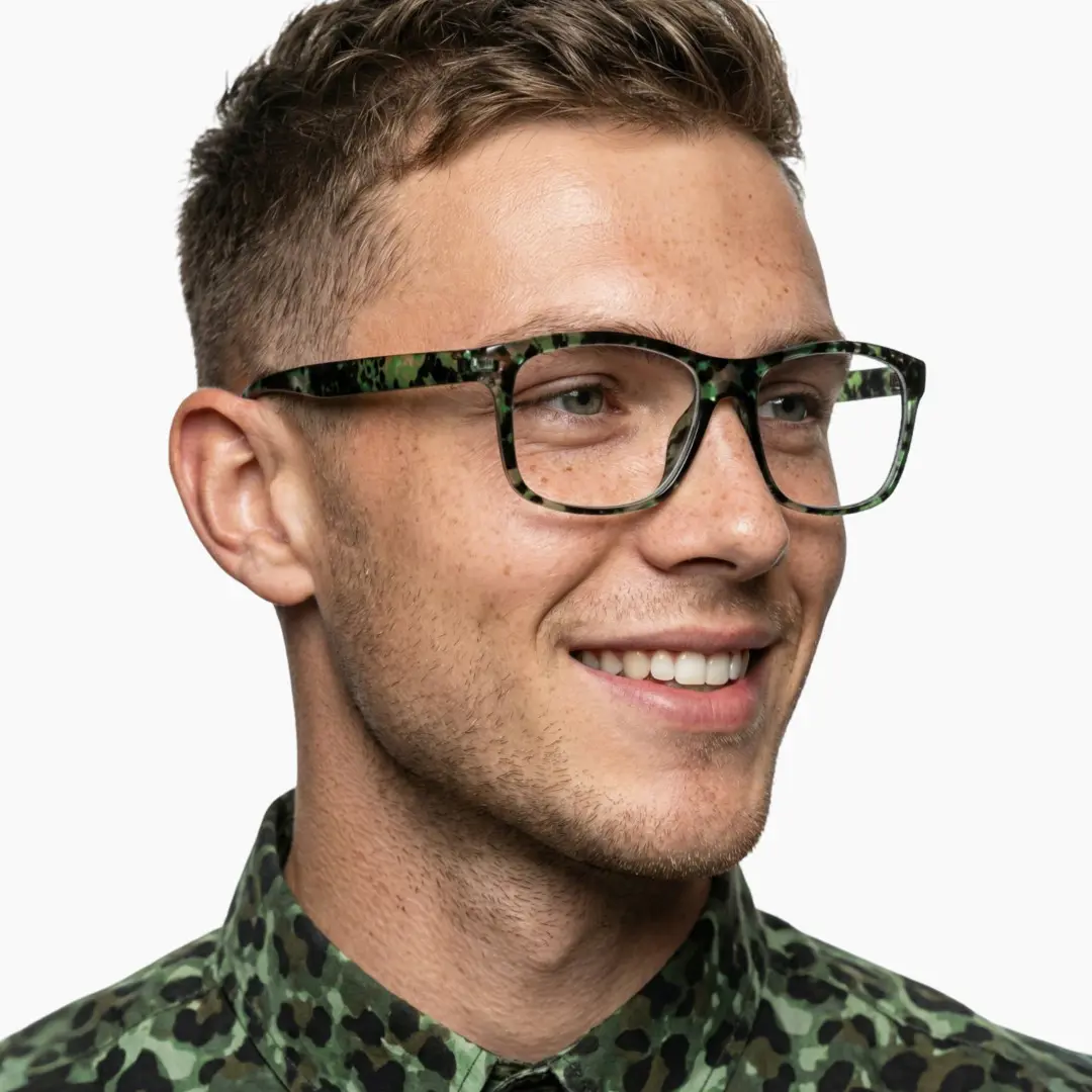 Looking away view of male wearing green rectangle eyeglasses, smiling, EP0032410