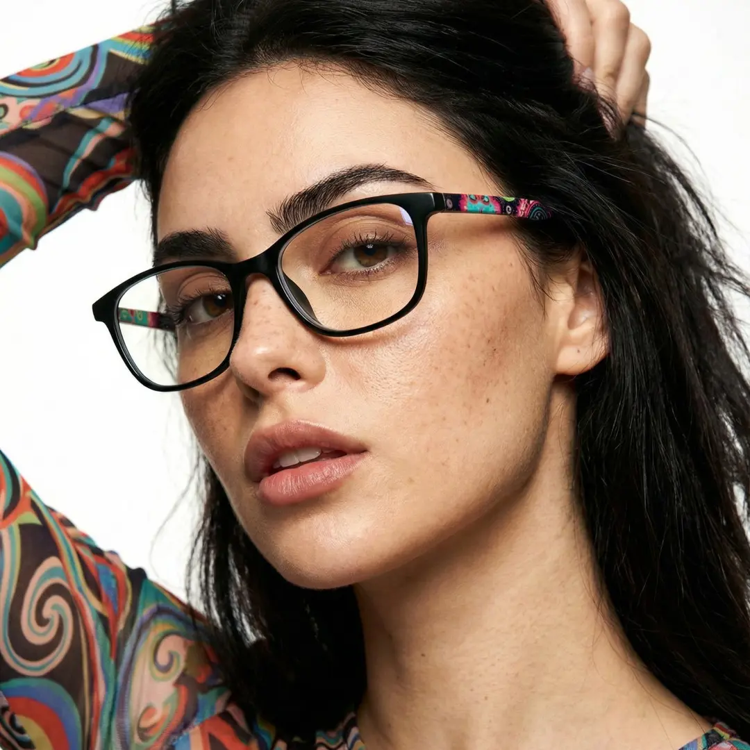 Face close-up view of female wearing green rectangle eyeglasses, hand in hair, confident expression, EP0312505