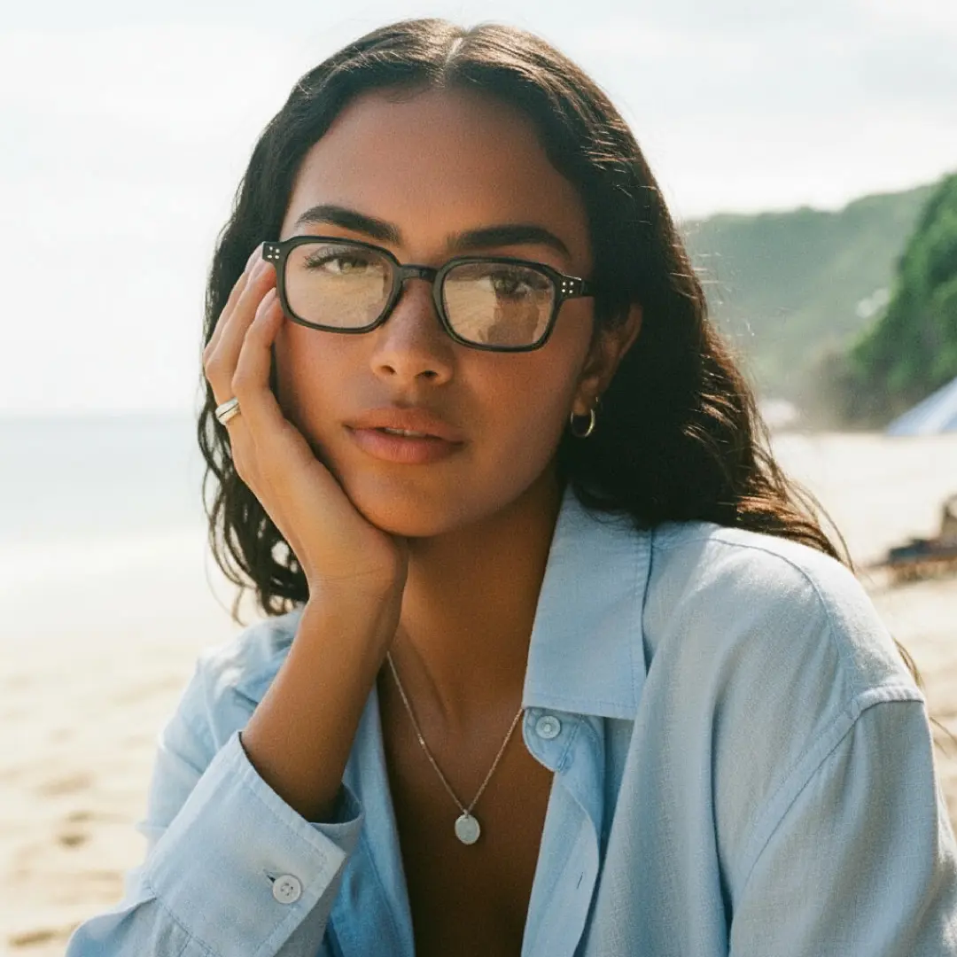 Front view of female wearing vintage black rectangle eyeglasses, resting chin on hand, neutral expression, EP0502509