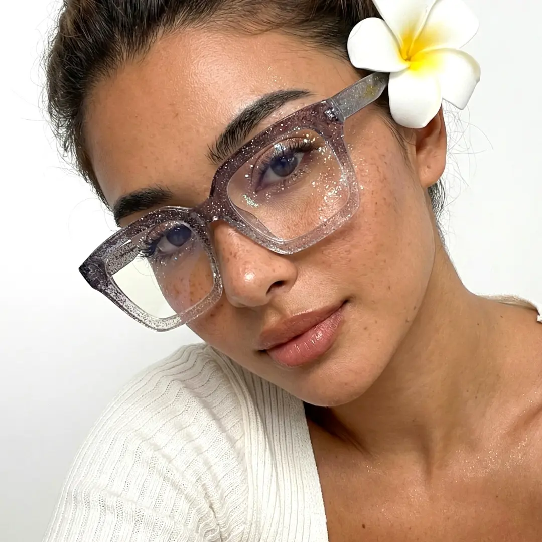 Tilted head view of female wearing grey rectangle eyeglasses, natural smile, ER0032504
