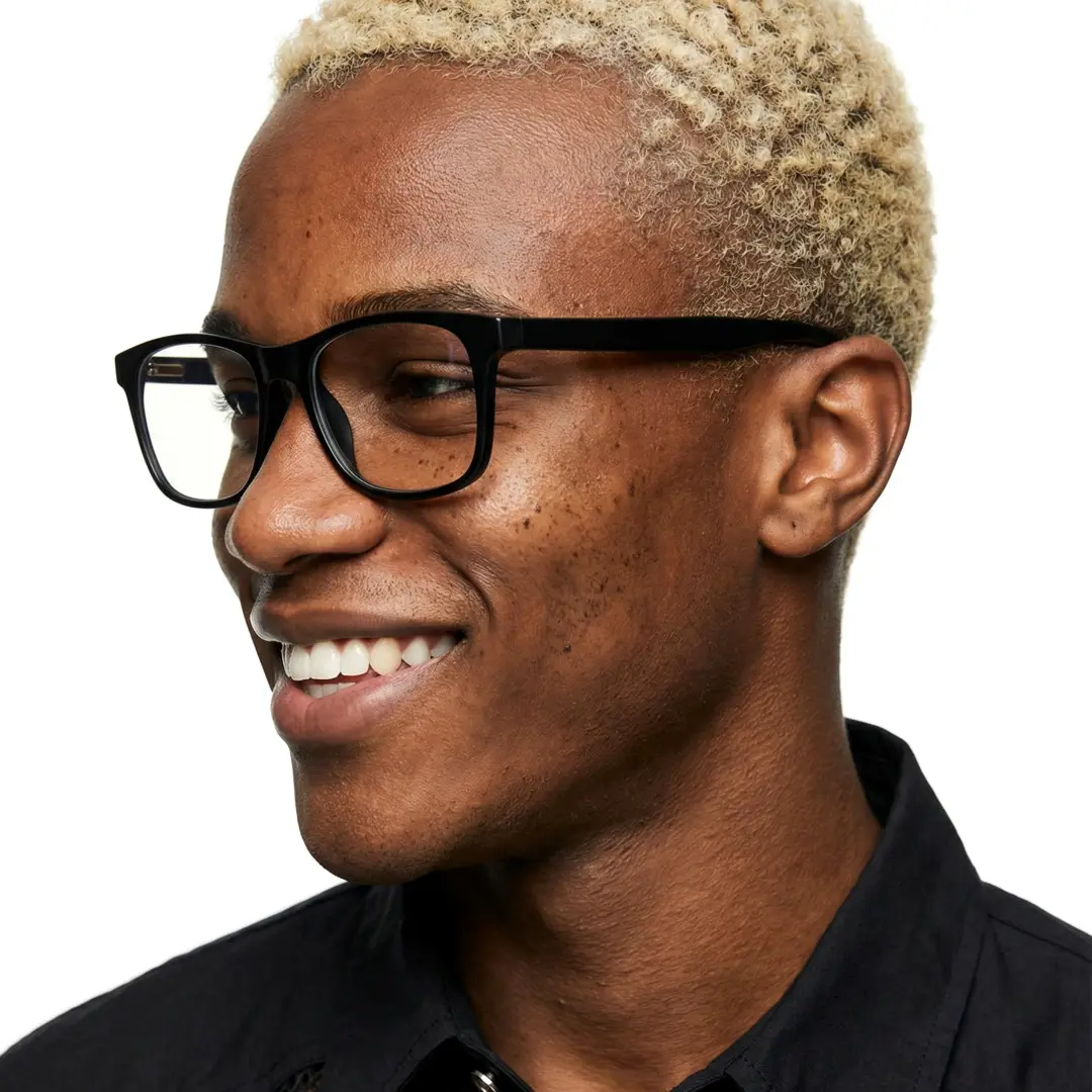 Three-quarter view of male wearing black rectangle eyeglasses, smiling, ER0122508