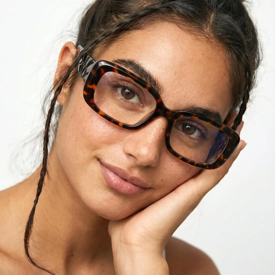 Tilted head view of female wearing y2k tortoise rectangle eyeglasses, hand near face, natural expression, ER0122510