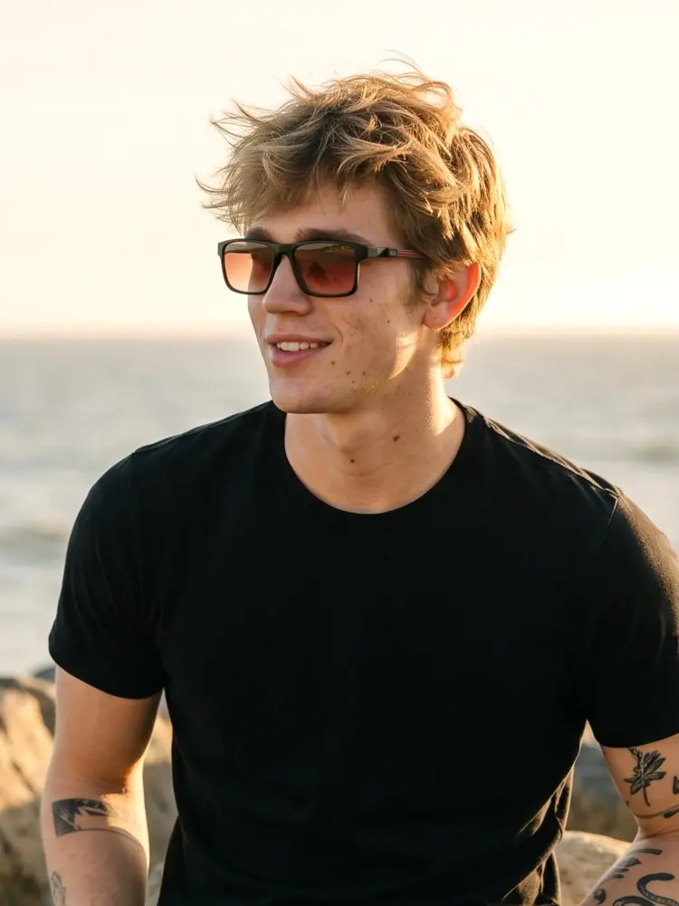 Male model wearing magnetic black rectangle tr90 magnetic clip on eyeglasses set with interchangeable clip on lenses on a sunny seaside beach background. SPU: ER0142508