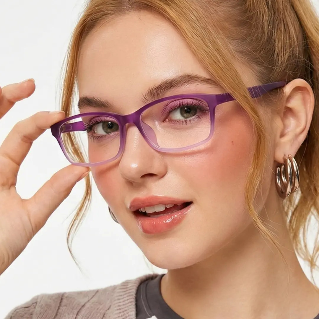 Face close-up view of female wearing purple rectangle eyeglasses, holding glasses, natural smile, ER0232411