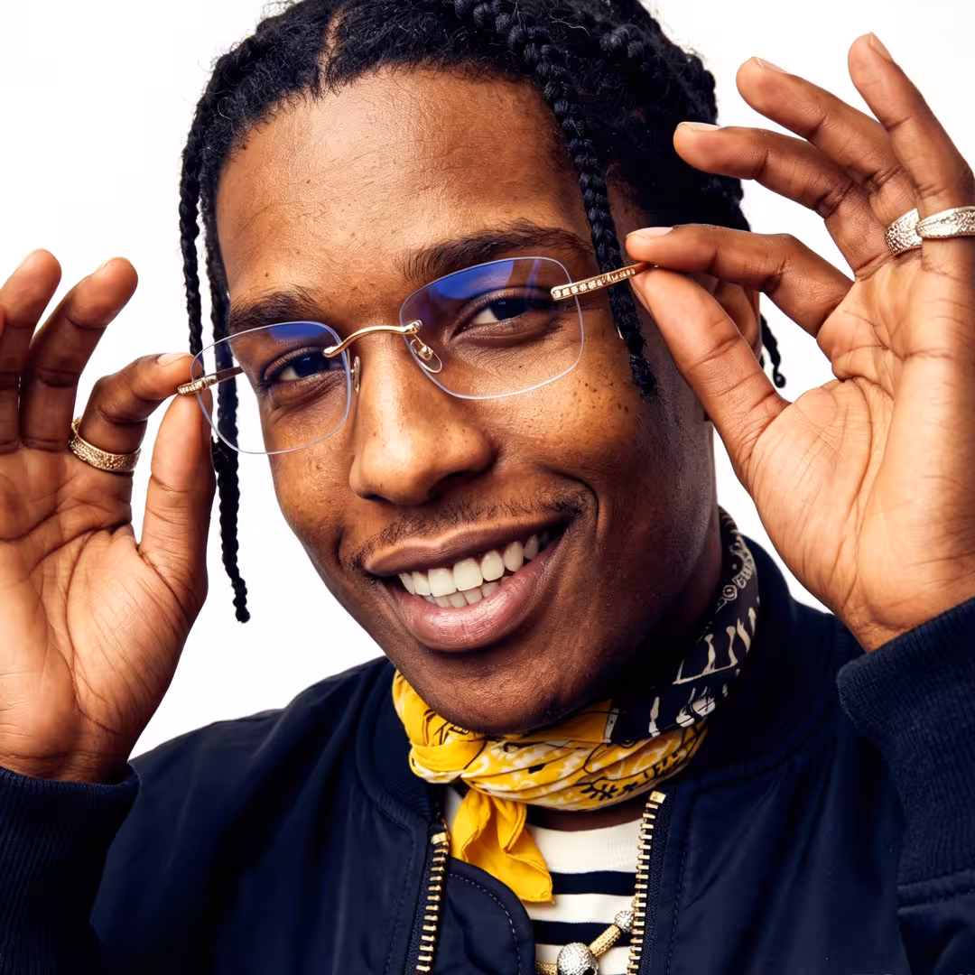 Front view of male wearing gold rectangle eyeglasses, touching frame, smiling, ET0022605