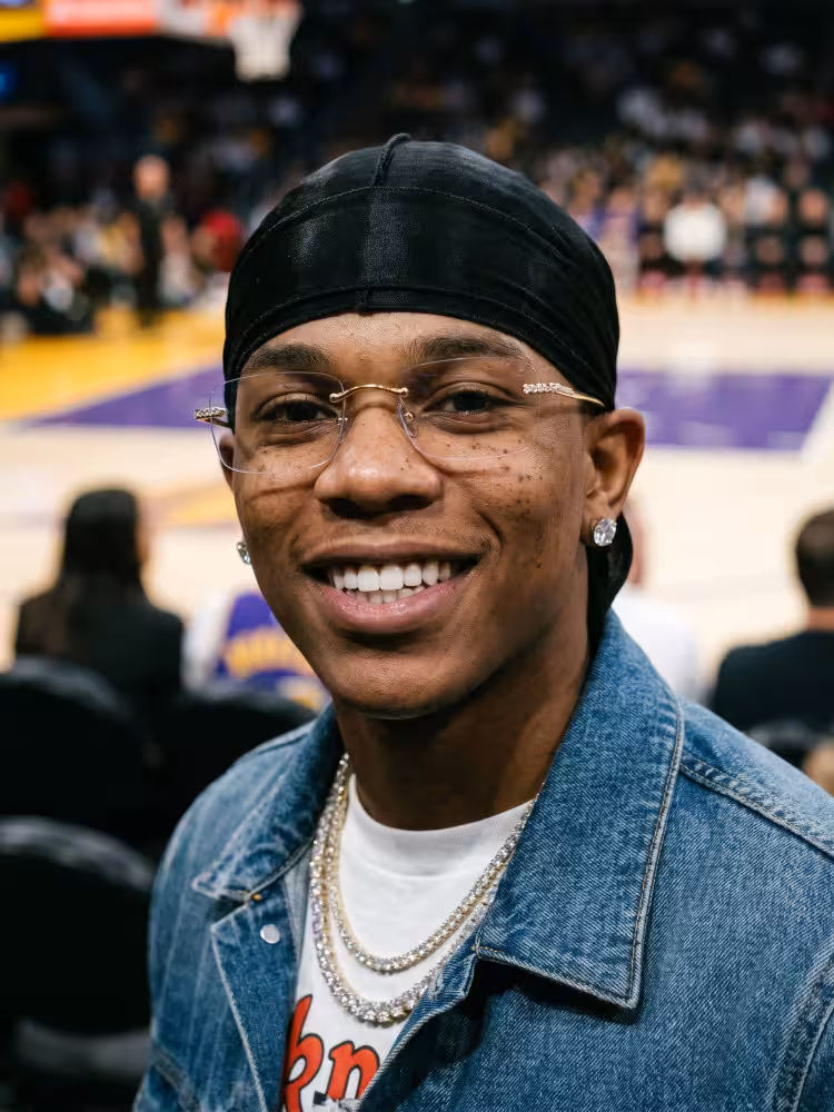 Male model wearing luxury gold rectangle titanium eyeglasses at a basketball arena. SPU: ET0022605