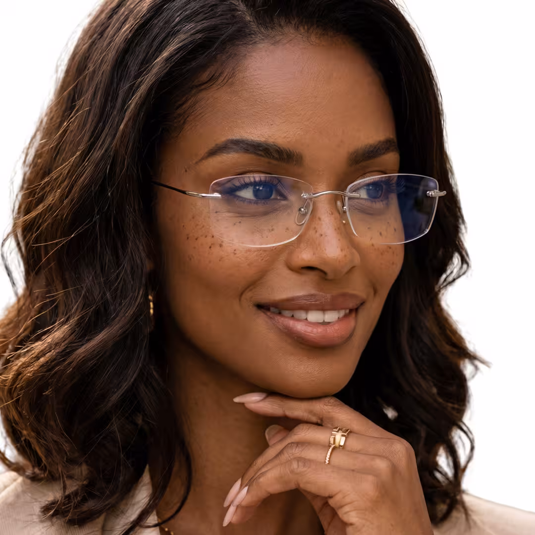 Female wearing silver rectangle titanium eyeglasses, smiling while resting chin on hand. SPU: ET0242605