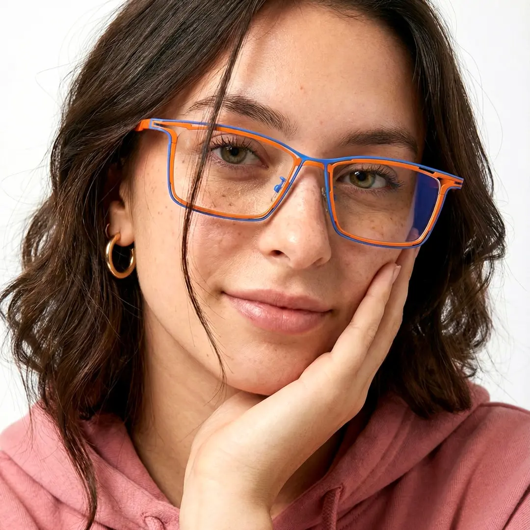 Tilted head view of female wearing two tone rectangle eyeglasses, resting chin on hand, natural smile, ET0352508