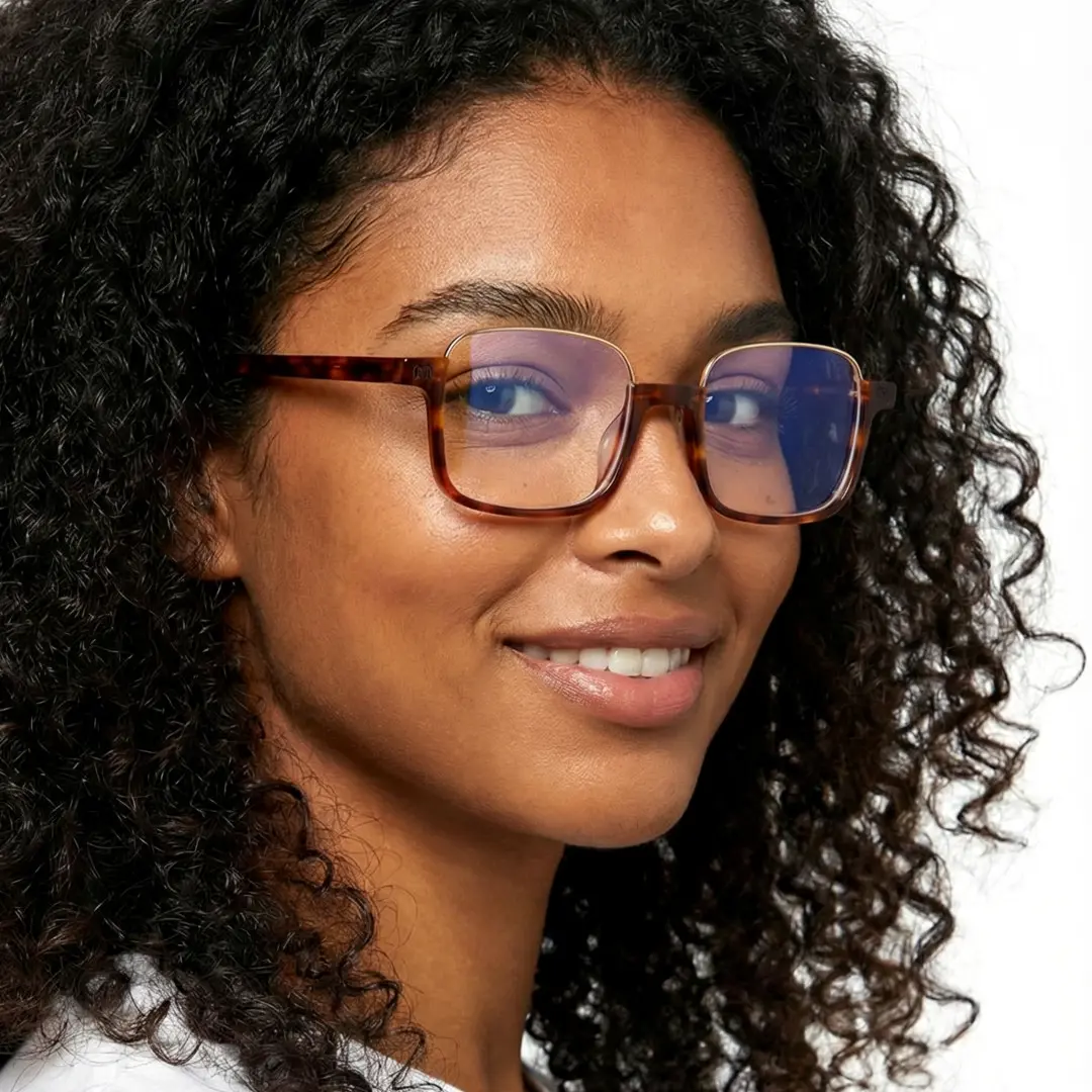 Profile view of female wearing tortoise rectangle eyeglasses, smiling, EX0382509