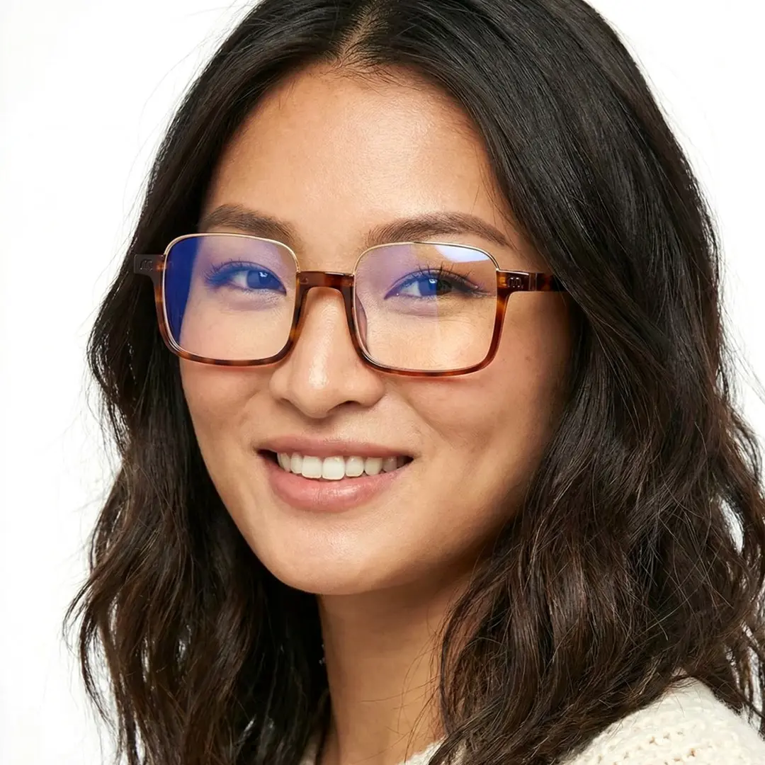 Three-quarter view of female wearing tortoise rectangle eyeglasses, smiling, EX0382509