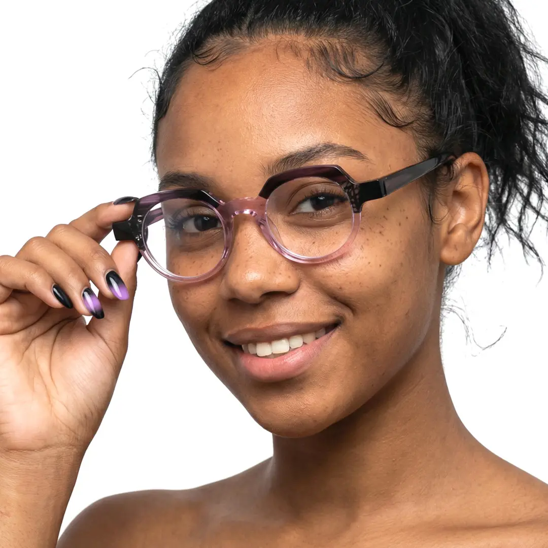 Three-quarter view of female wearing pink geometric eyeglasses, holding glasses, soft smile, GA0032209