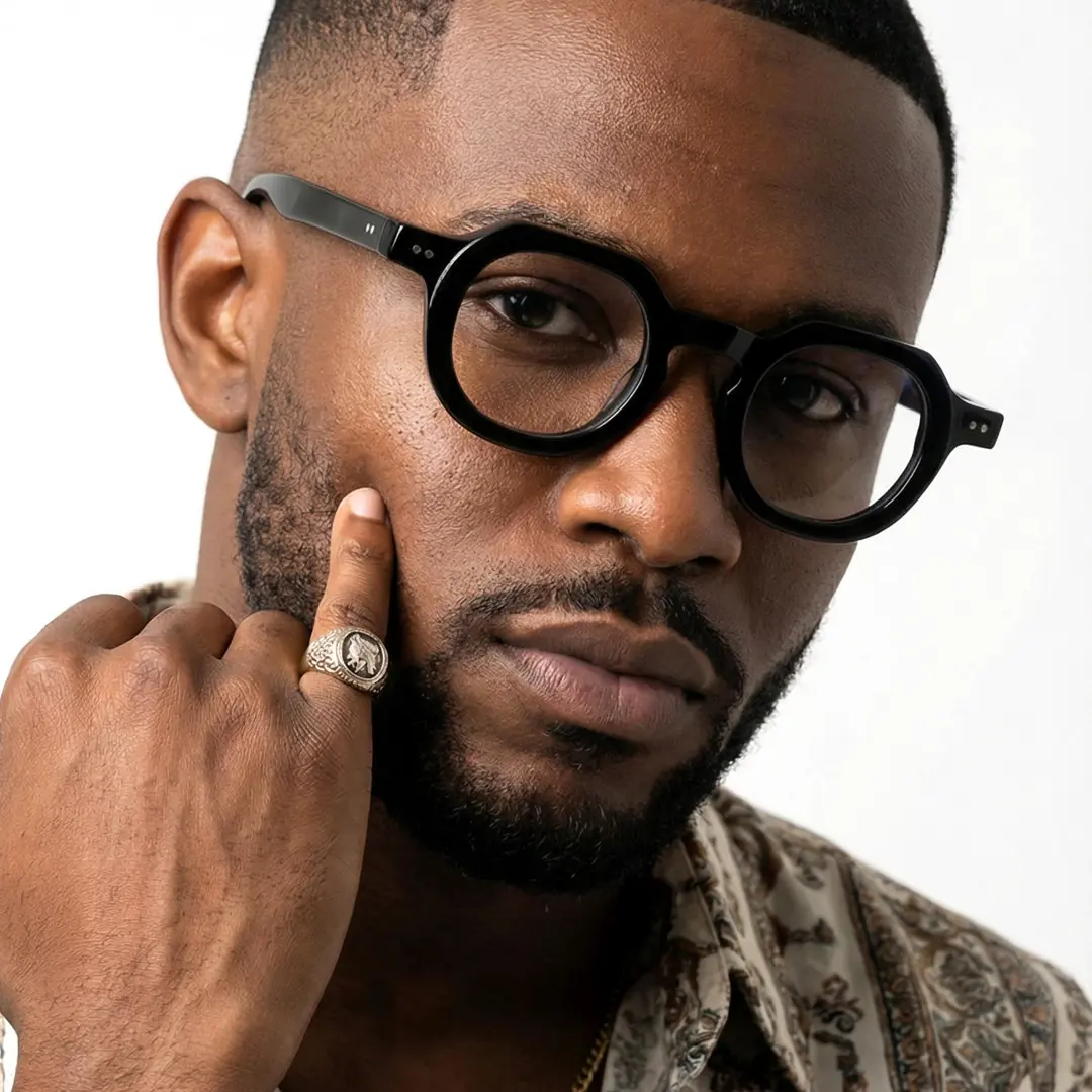 Profile view of male wearing vintage black geometric eyeglasses, resting chin on hand, calm expression, GA0032301