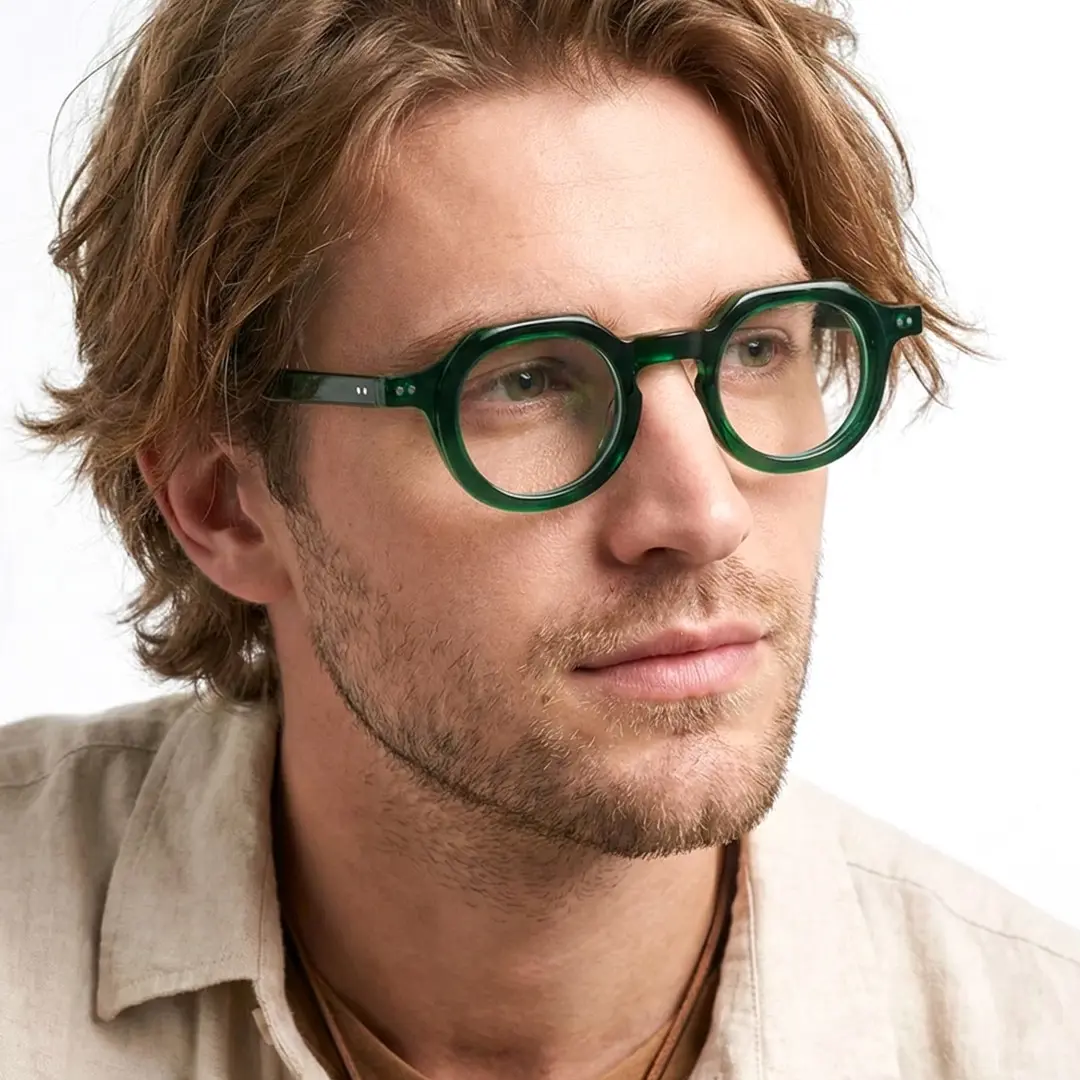 Looking away view of male wearing vintage green geometric eyeglasses, thoughtful expression, GA0032301