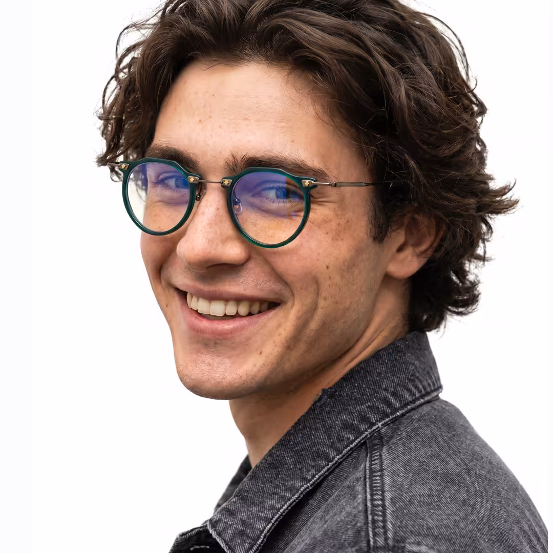 Over-the-shoulder view of male wearing steampunk green geometric eyeglasses, smiling, GA0072307