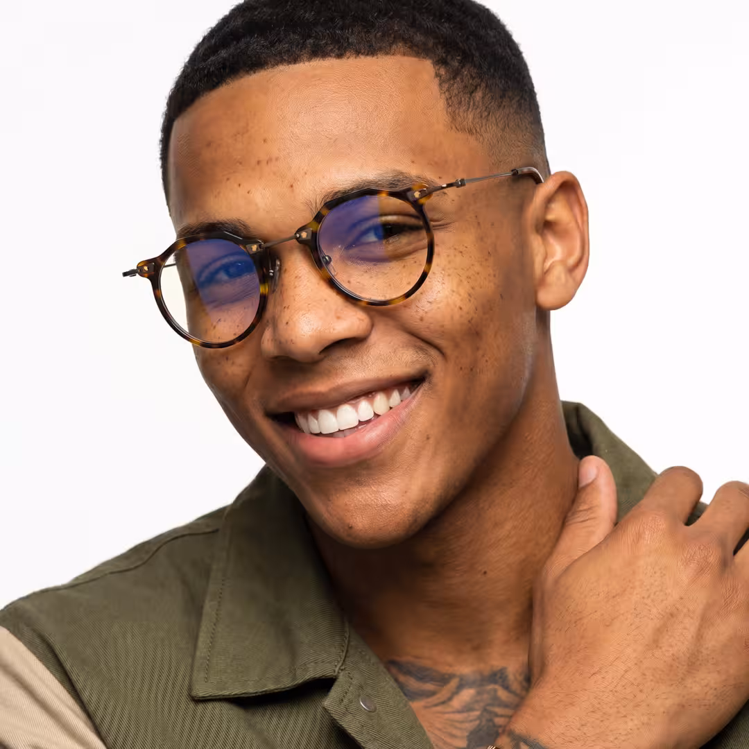 Front view of male wearing steampunk tortoise geometric eyeglasses, smiling, GA0072307