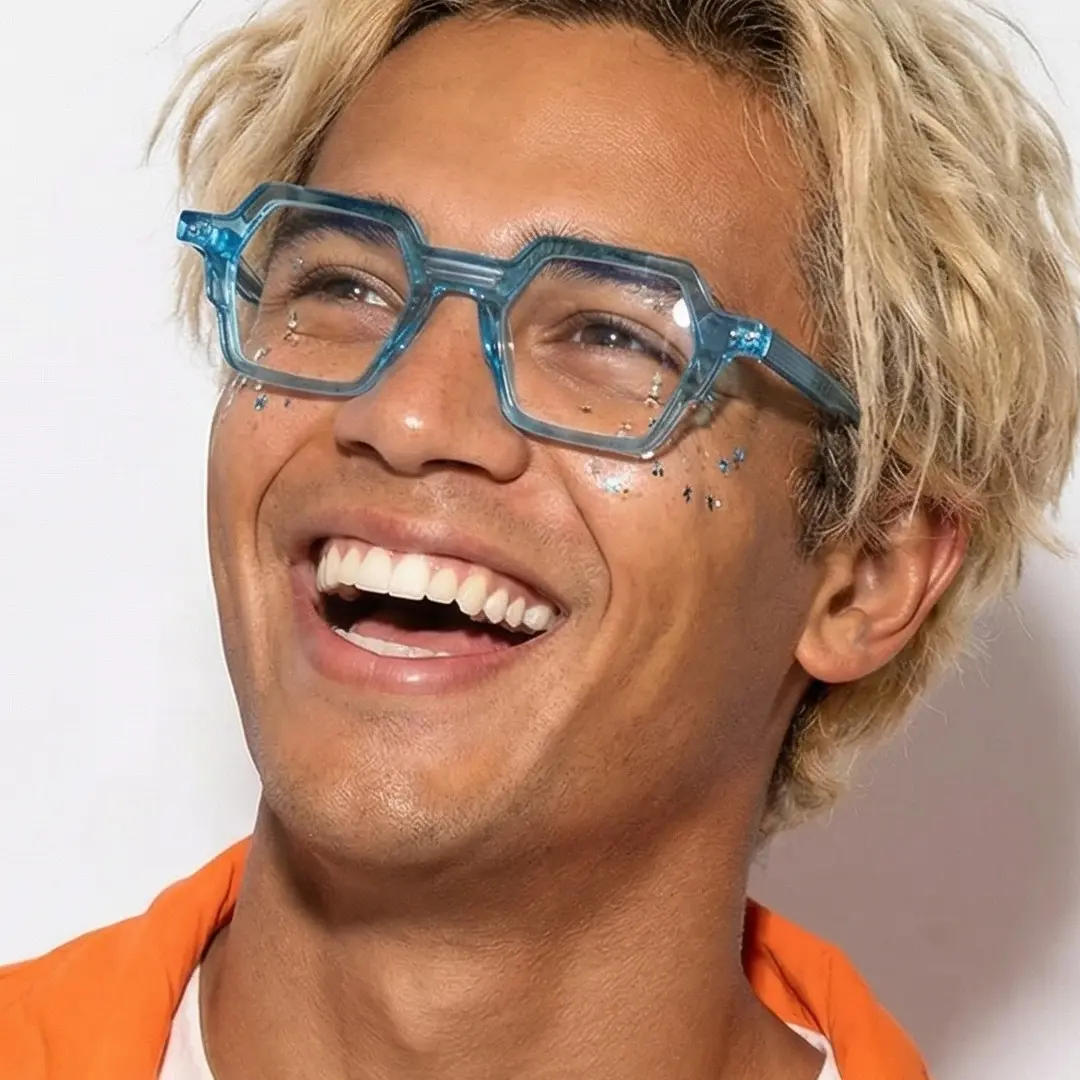 Three-quarter view of male wearing blue geometric eyeglasses, open mouth, smiling, GA0132302