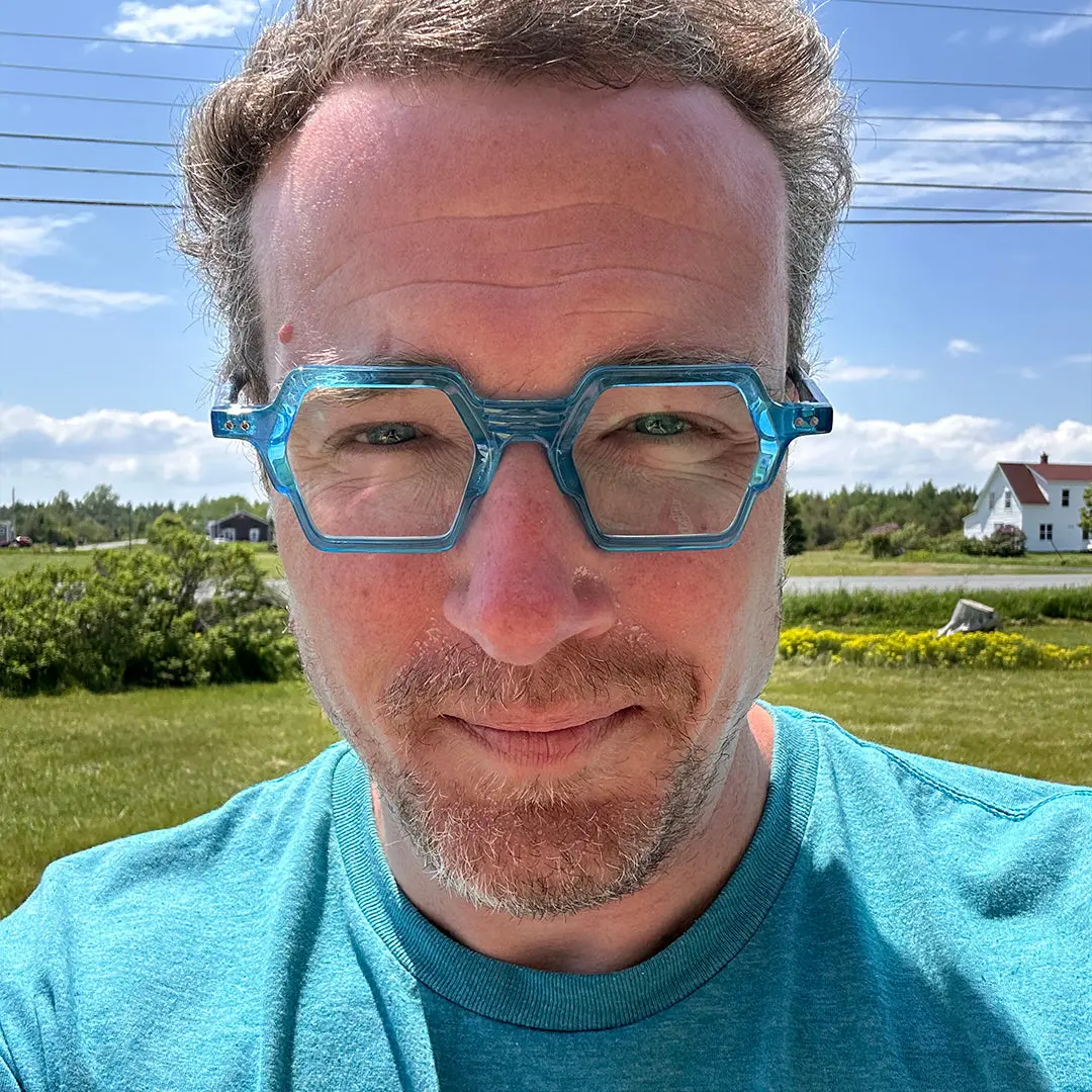 Front view of male wearing fashion blue geometric eyeglasses, calm expression, GA0132302