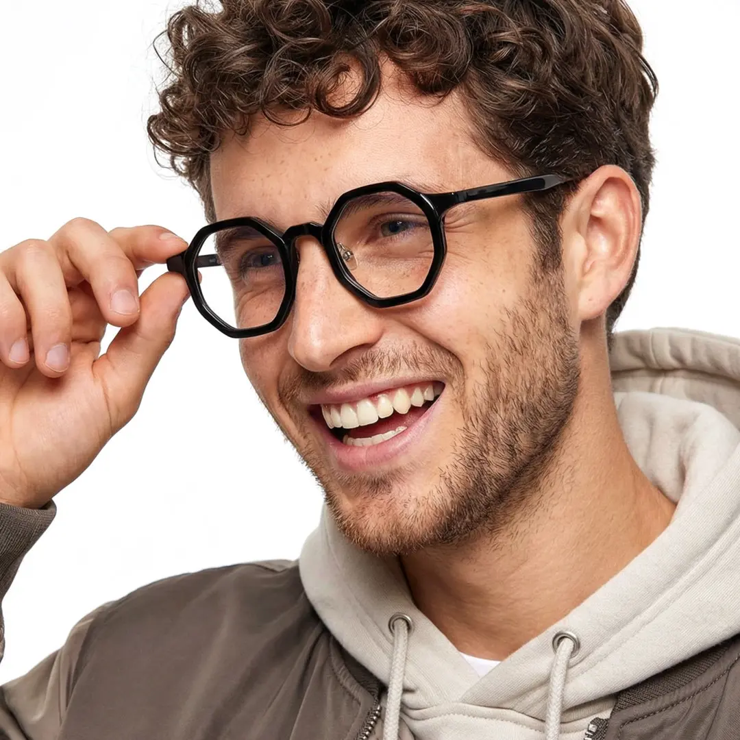 Front view of male wearing vintage black geometric eyeglasses, touching frame, smiling, GA0162302
