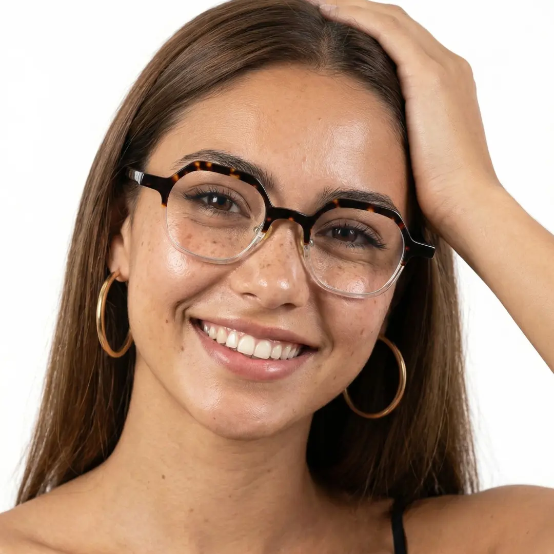 Front view of female wearing vintage tortoise geometric eyeglasses, hand in hair, smiling, GA0182209