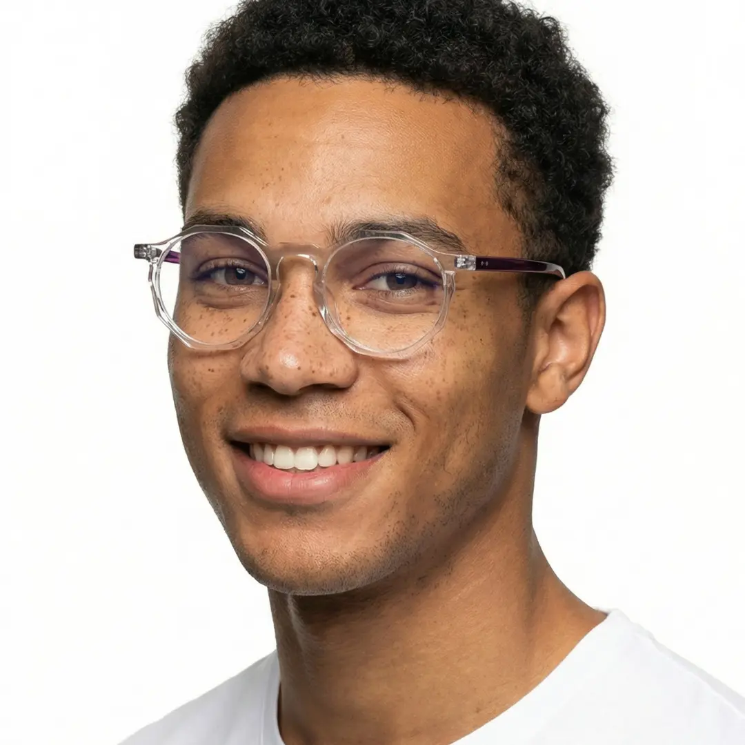 Three-quarter view of male wearing clear geometric eyeglasses, smiling, GA0212403