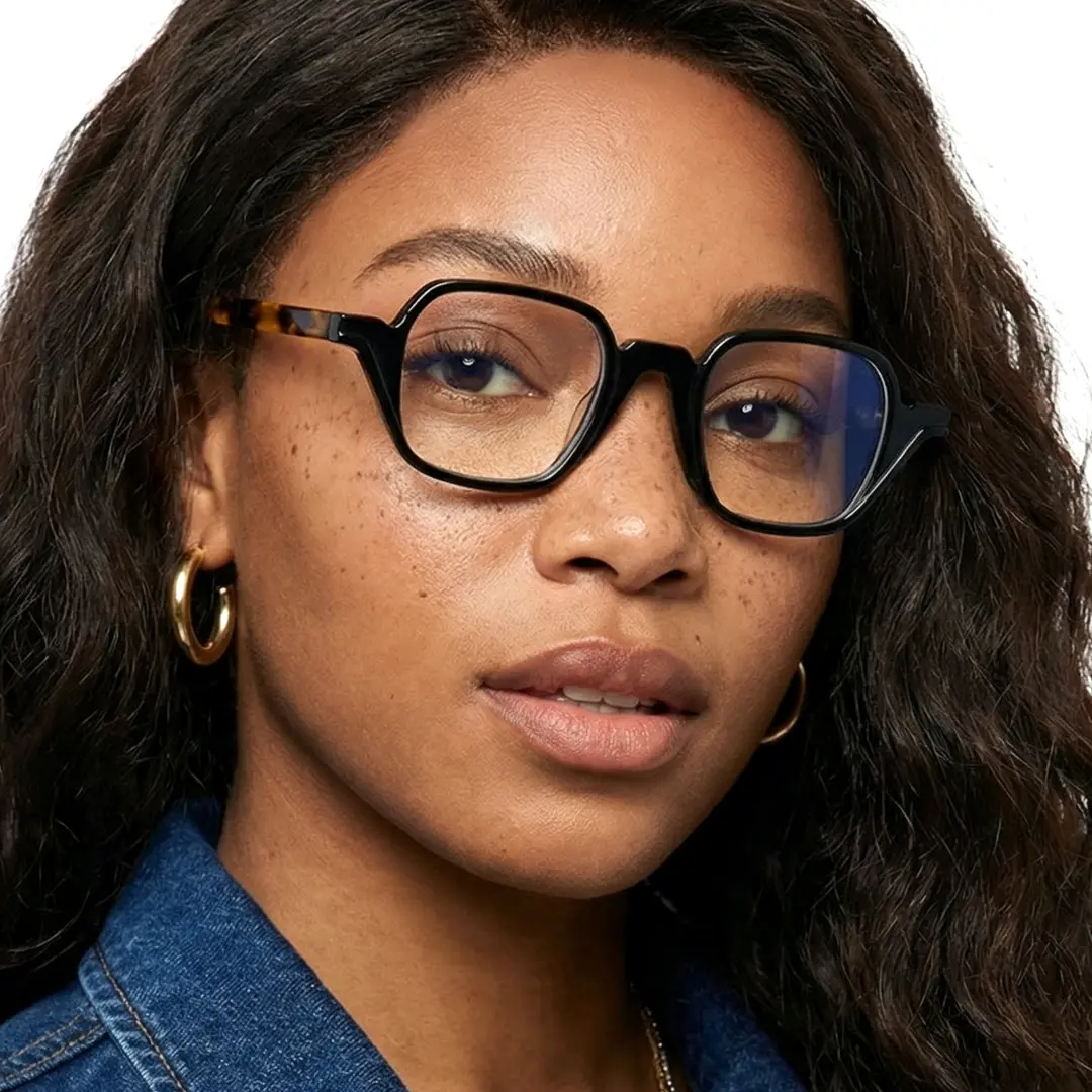 Over-the-shoulder view of female wearing vintage black geometric eyeglasses, neutral expression, GA0242306