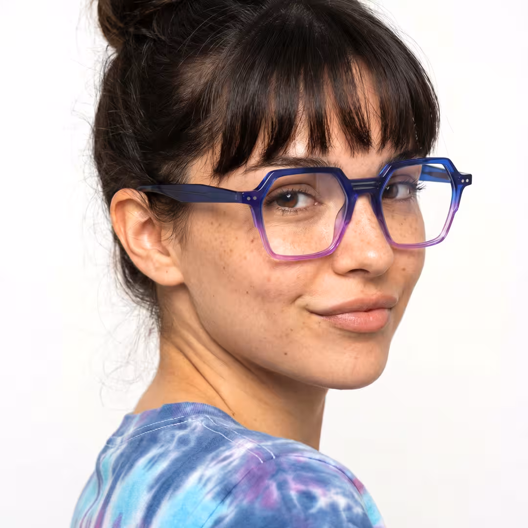 Over-the-shoulder view of female wearing purple geometric eyeglasses, natural smile, GA0412503
