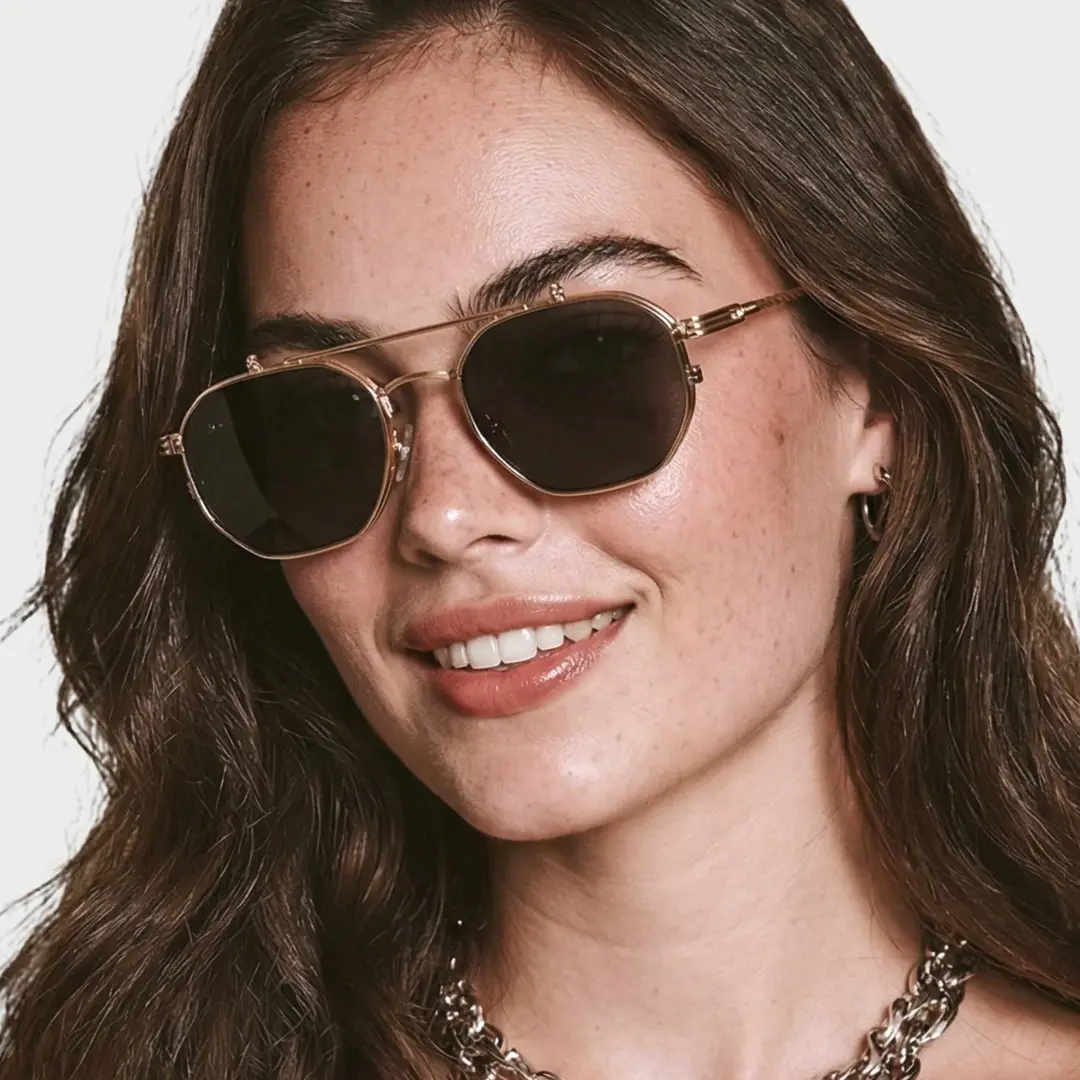 Three-quarter view of female wearing gold geometric flip-up eyeglasses, natural smile, GM0052601