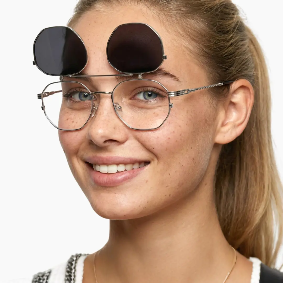 Three-quarter view of female wearing silver geometric eyeglasses, smiling, GM0052601