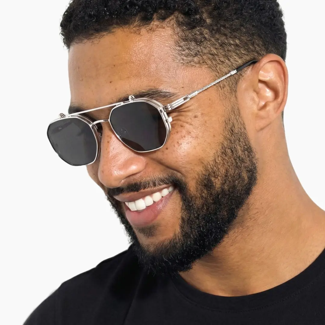 Profile view of male wearing silver geometric flip-up eyeglasses, smiling, GM0052601
