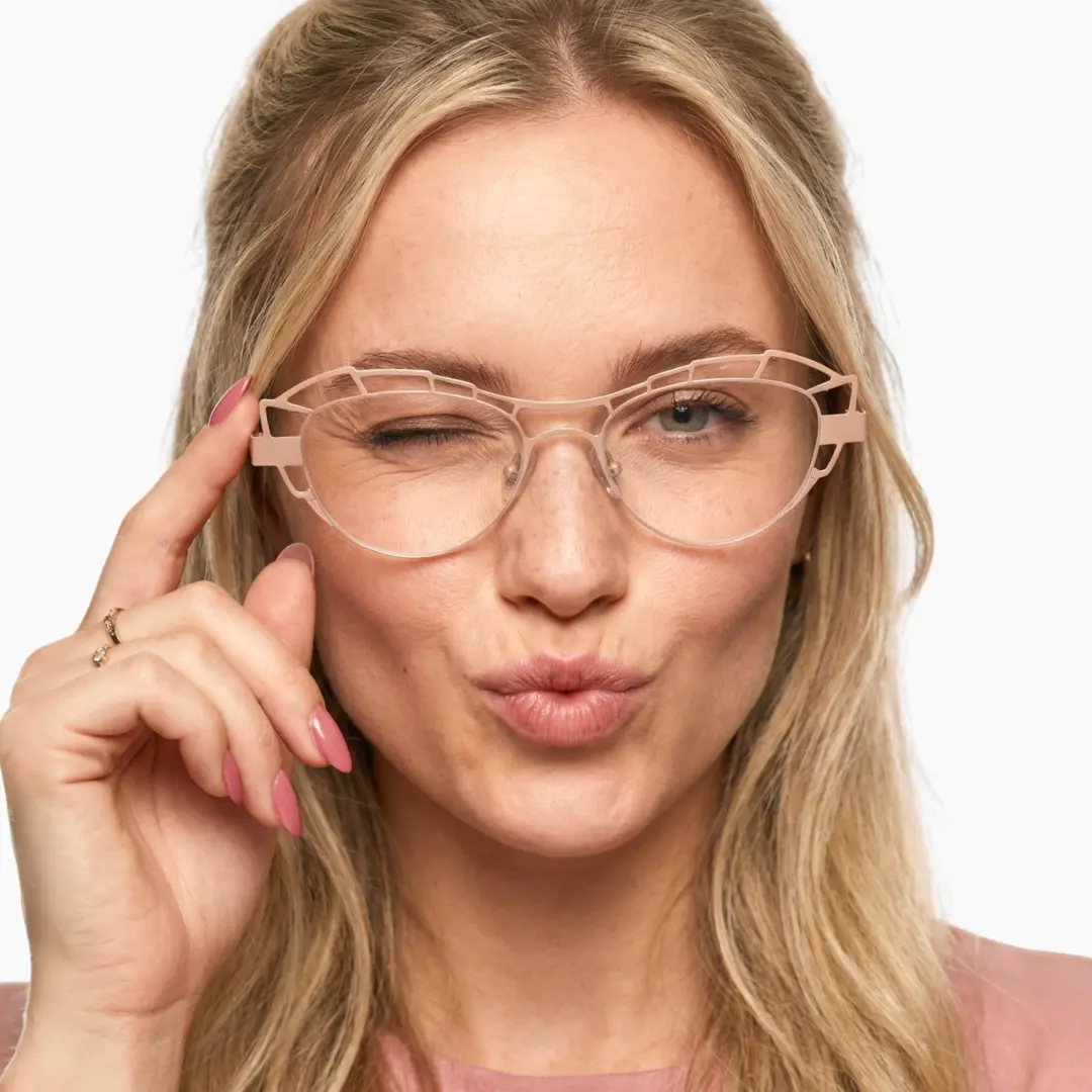 Close-up view of female wearing beige geometric eyeglasses, winking, touching frame, GM0062212