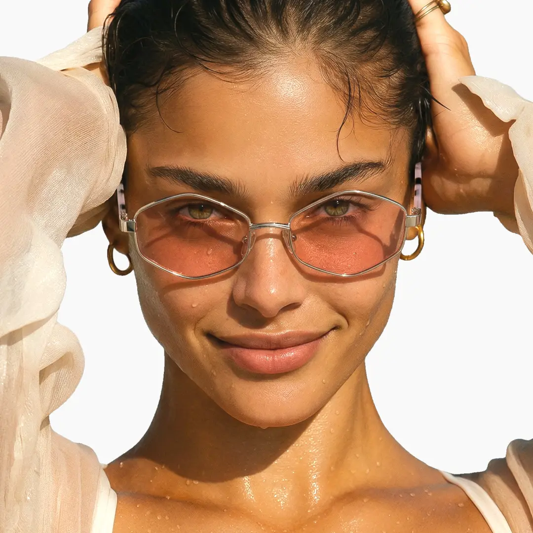 Front view of female wearing fashion pink geometric sunglasses, hand in hair, natural expression, GM0062601