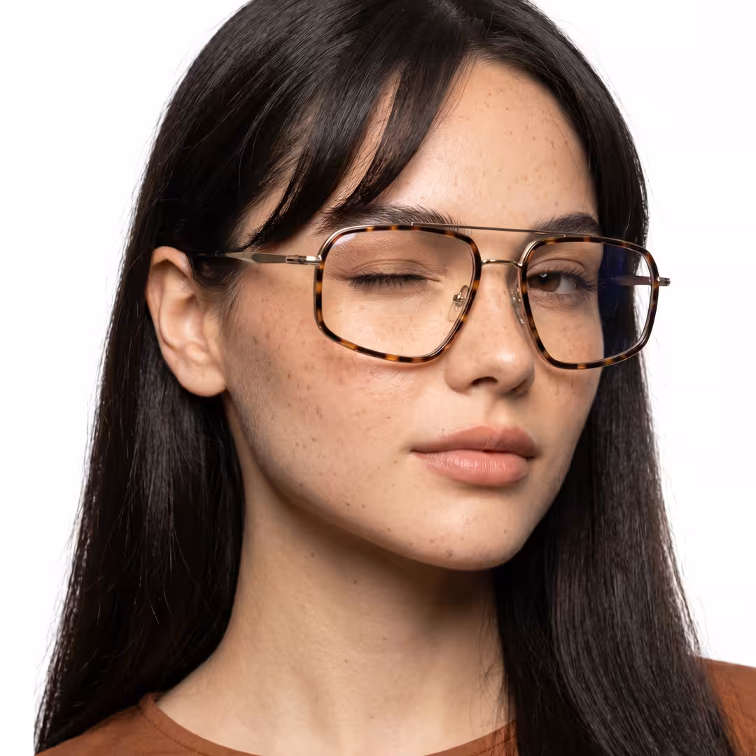Female wearing vintage tortoise geometric metal eyeglasses, soft smile while winking. SPU: GM0072605
