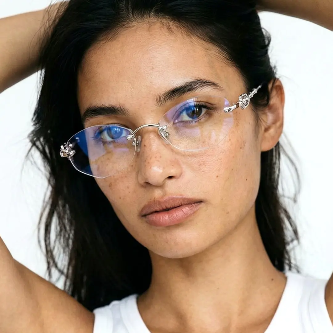 Looking straight ahead view of female wearing fashion silver geometric eyeglasses, hand in hair, natural expression, GM0192601